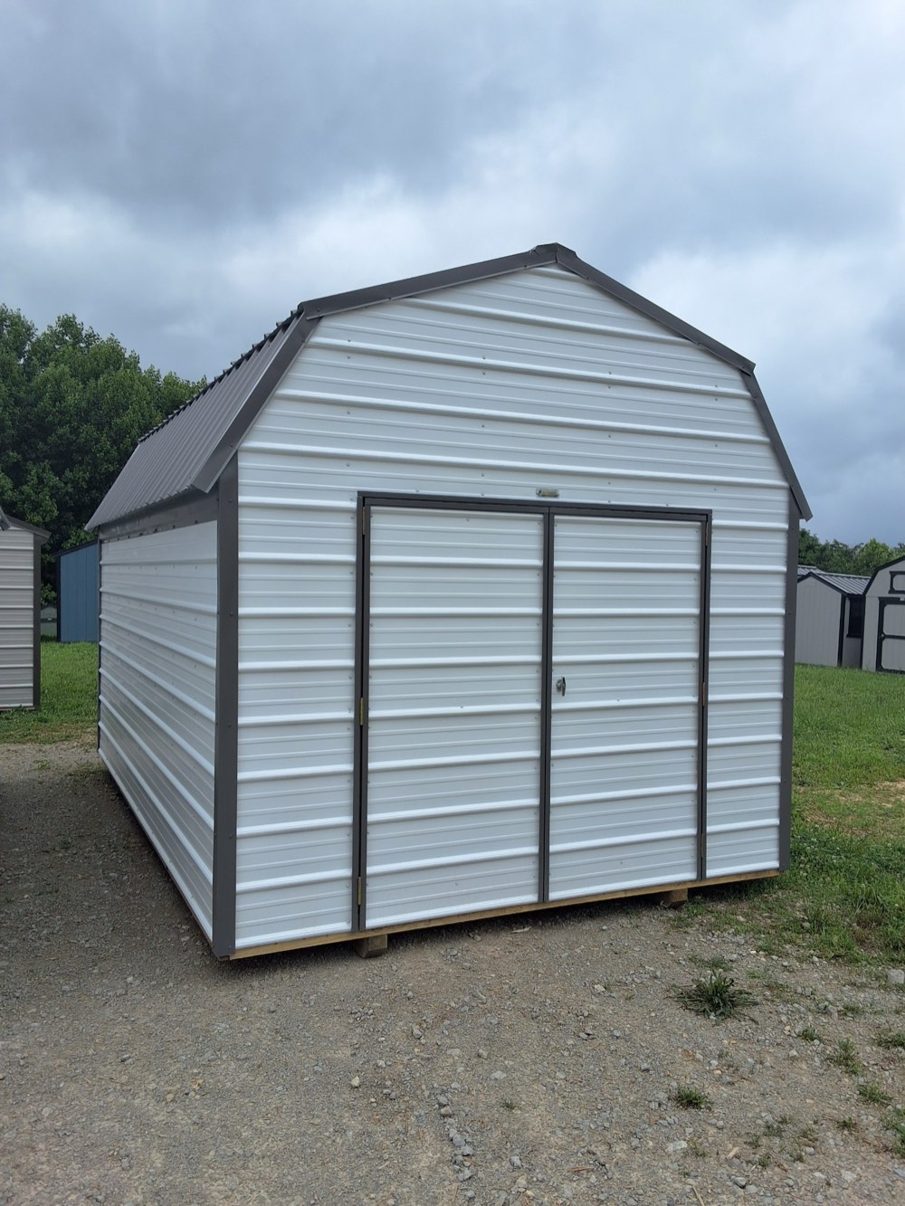 Metal lofted barn, 10 by 16, white horizontal metal siding with gray trim